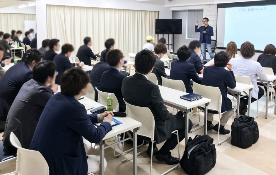 プロジェクターに映ったグラフを指差しながら発表をしているビジネスマン