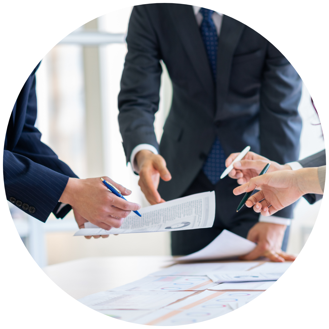 書類とペンを持って３人のビジネスマンが議論している様子